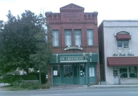 The building before we took it over: the two-story brick corner on Orange Street in downtown Redlands under the prior operator's green Joe Greensleeves sign, the street quiet in front of it. Source: a guest's photo on the public Yelp listing for Joe Greensleeves, now closed.